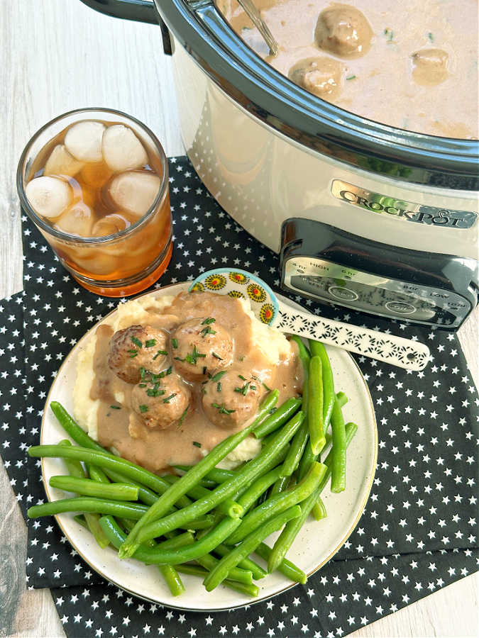 frozen meatballs cooked in the crock pot with a Swedish meatball sauce, plated with mashed potatoes and green beans