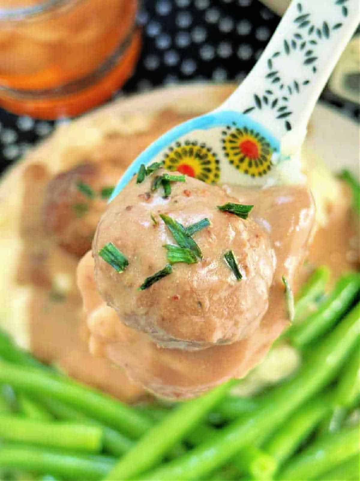 close up photo of Swedish meatball in a spoon