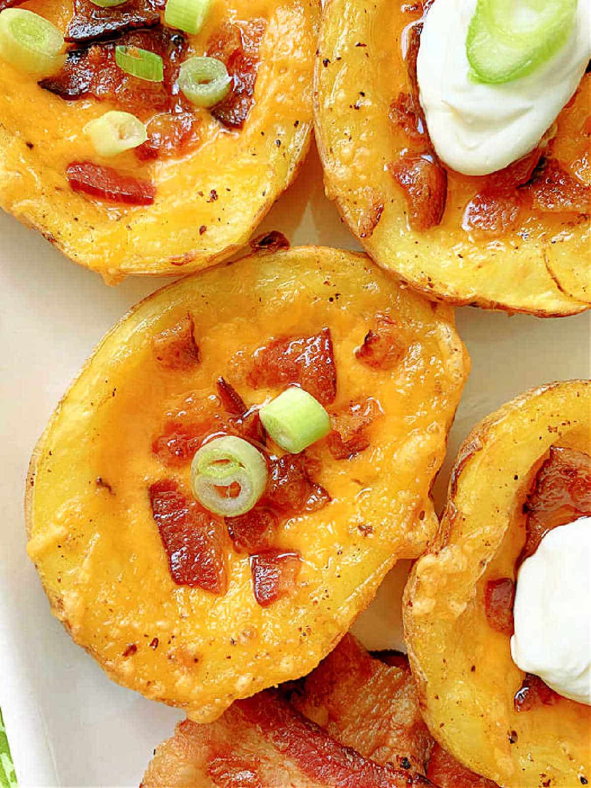 close up photo of a potato skin filled with melty cheese and bacon