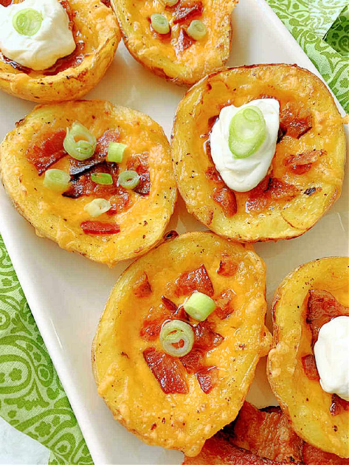 plated air fryer potato skins garnished with sour cream and green onions