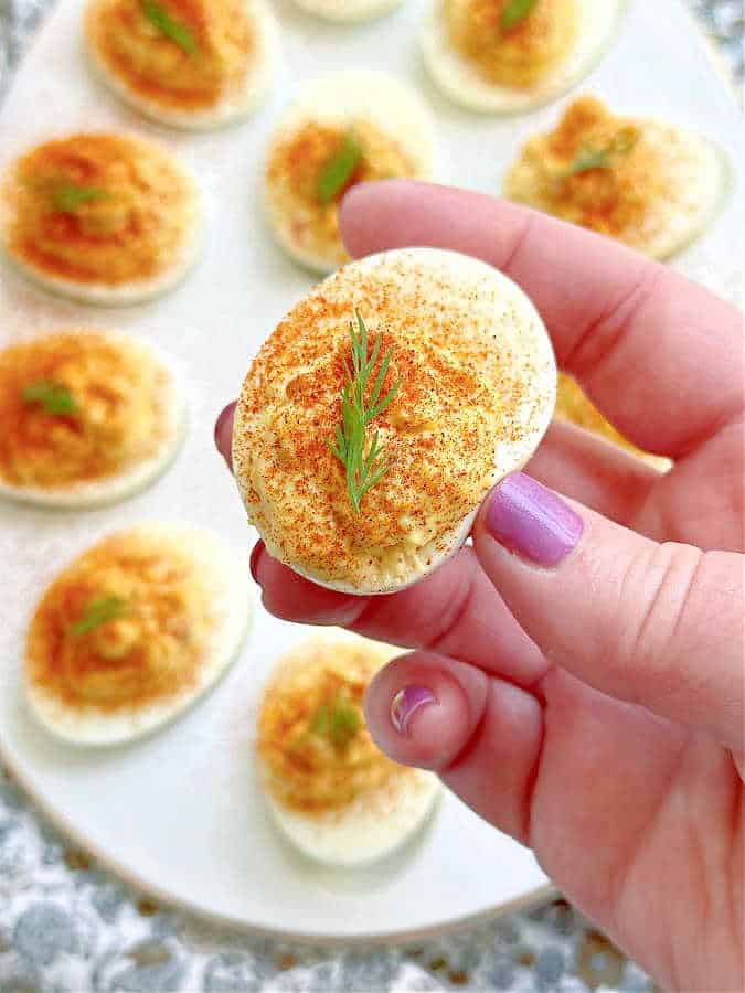 taking a bite of a deviled egg with relish