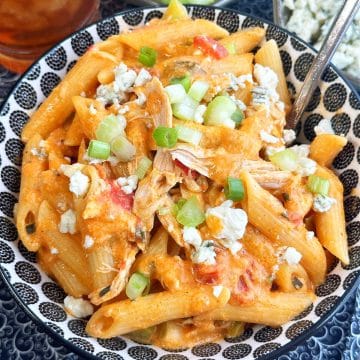 a full bowl of buffalo chicken pasta garnished with crumbled blue cheese and fresh celery and green onions