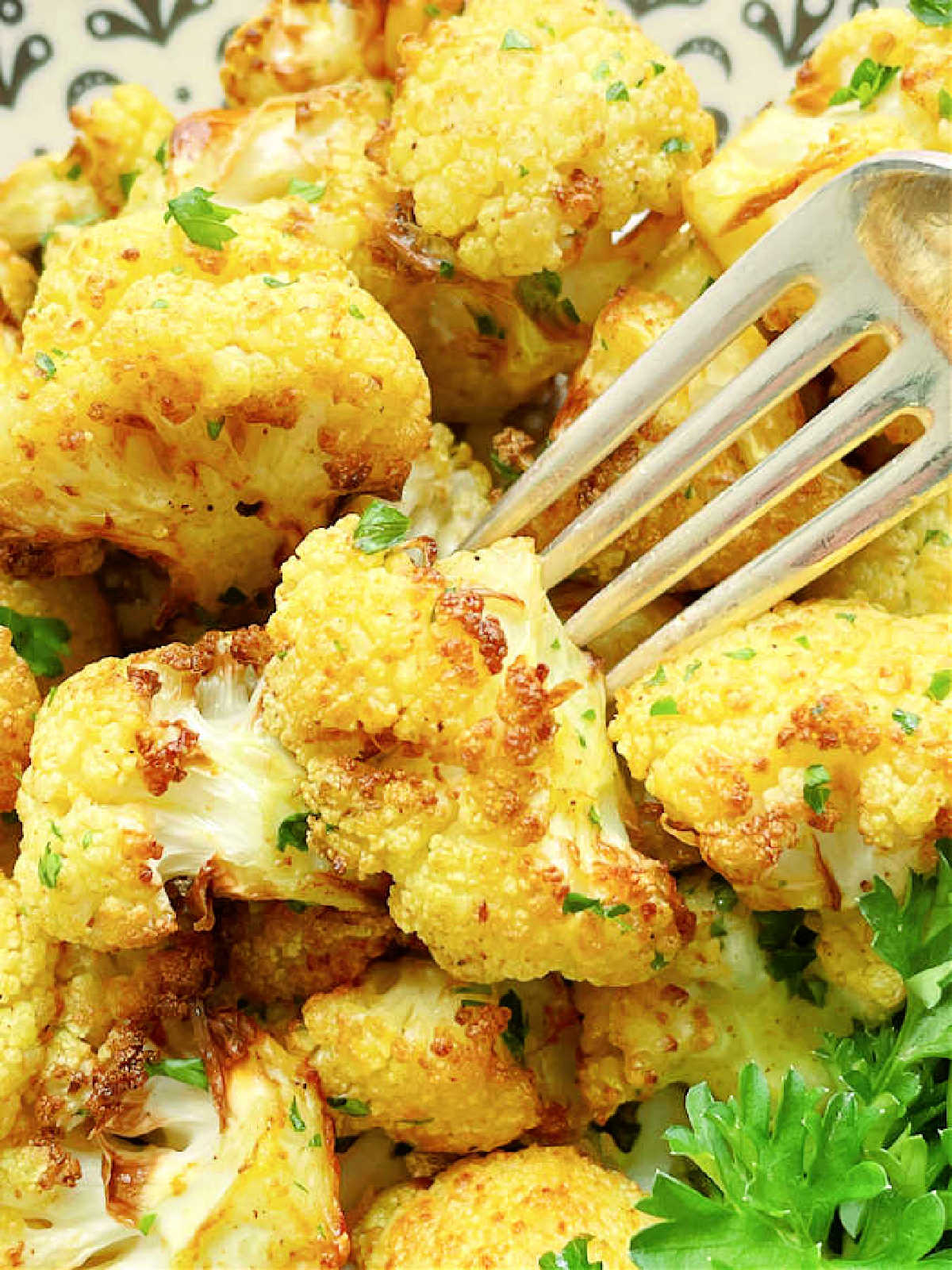 using a fork to take a bite of air fryer curried cauliflower