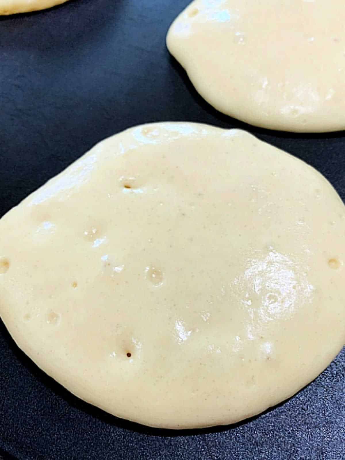 showing bubbles in pancakes that are ready to flipped on the griddle