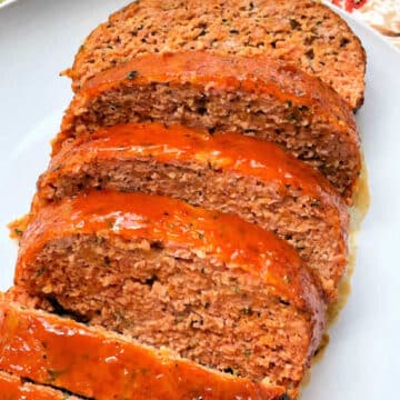 apricot glazed ham loaf sliced and on a white plate