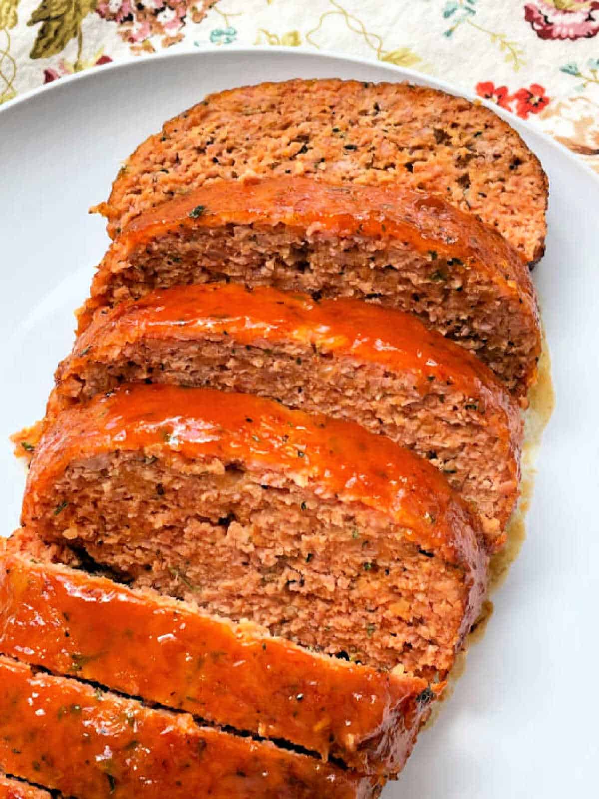 showing the freshly baked ham loaf sliced on a white plate