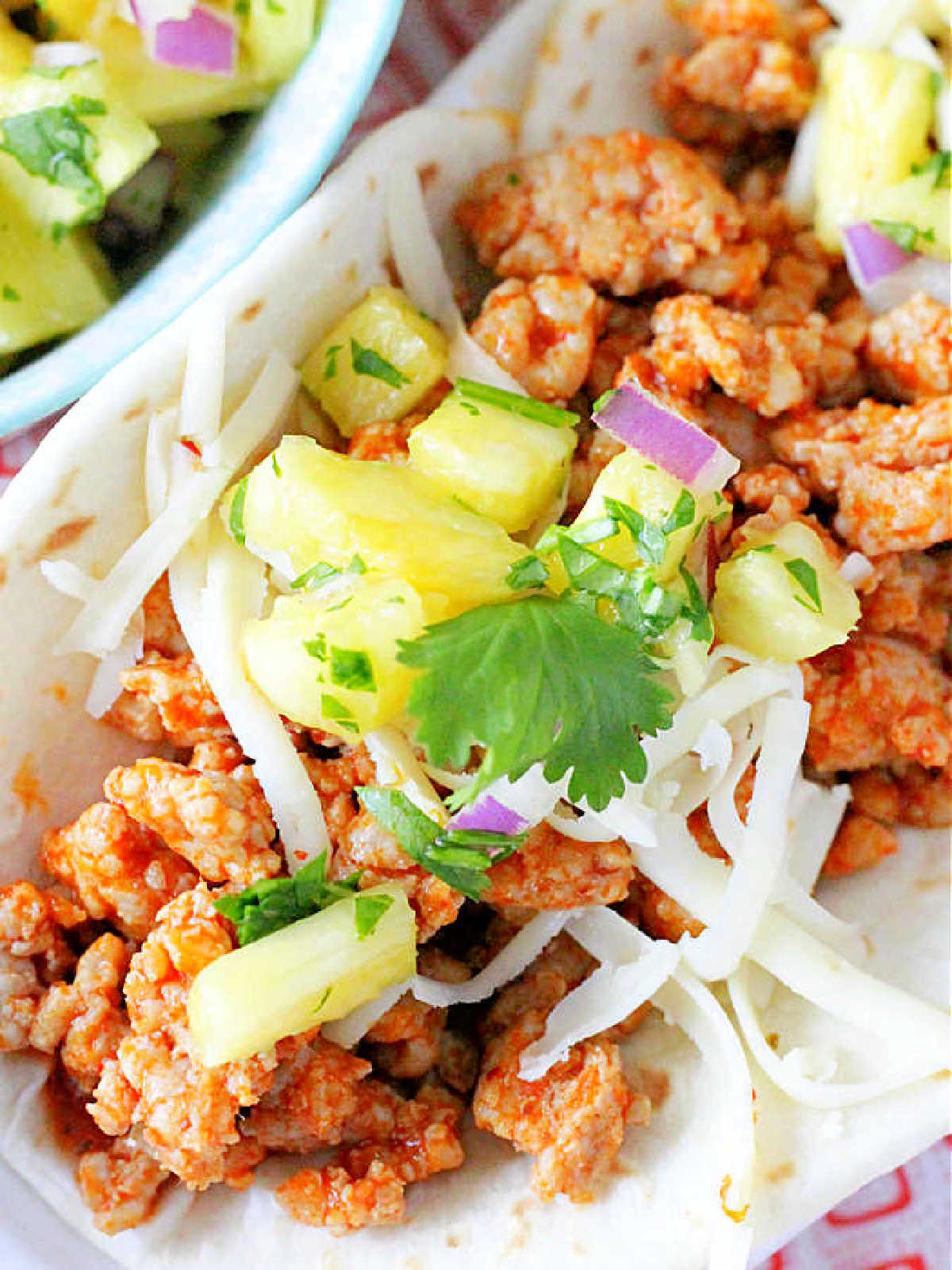 close up of the ground pork taco meat inside of a flour tortilla