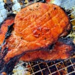 broiled bone-in pork chops stacked on a baking rack