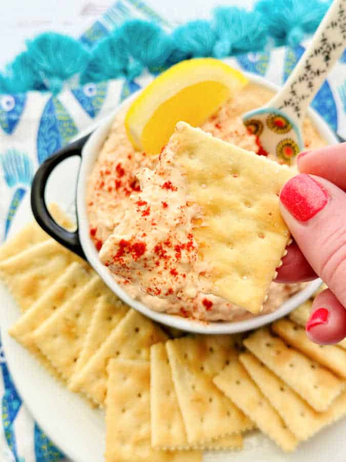 dipping a saltine cracker into the smoked tuna dip
