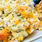 serving a slice of easy sausage biscuits and gravy breakfast casserole recipe from the baking dish