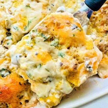serving a slice of easy sausage biscuits and gravy breakfast casserole recipe from the baking dish