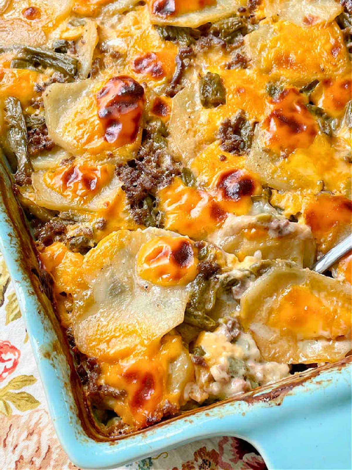 freshly baked hamburger potato casserole in a turquoise casserole dish