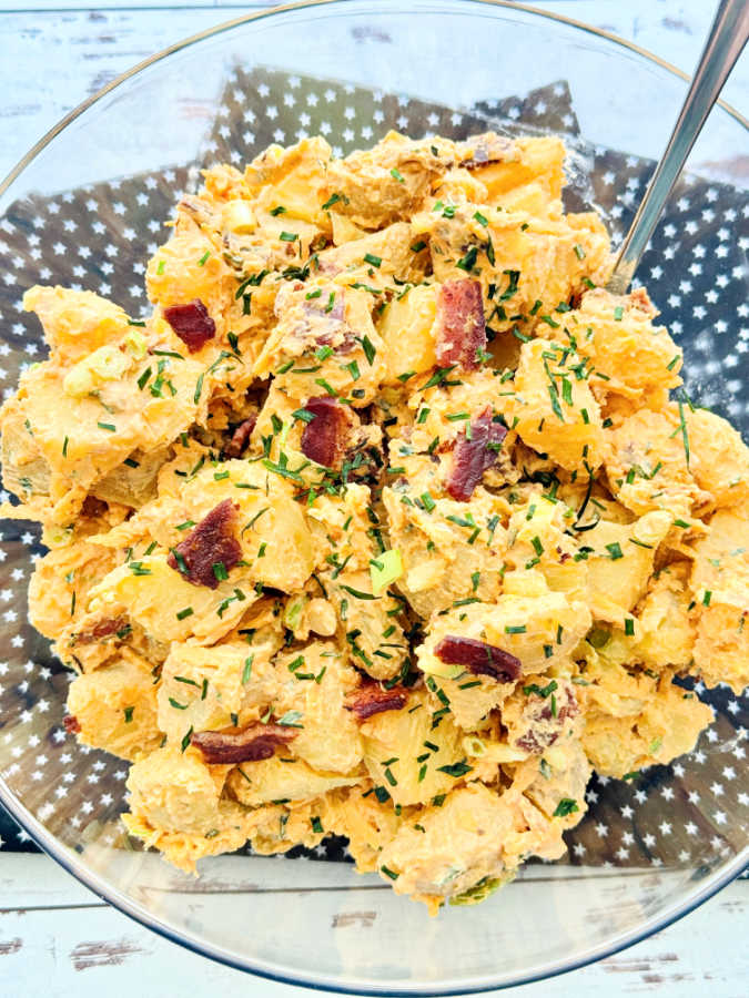 a big bowl of loaded baked potato salad with bacon