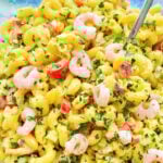 bright yellow shrimp macaroni salad in a serving bowl