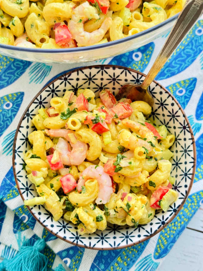 large serving bowl and small single serving bowl filled with the shrimp macaroni salad