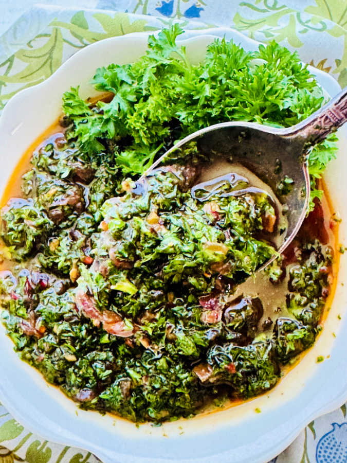 a close up picture of a spoonful of homemade chimichurri sauce