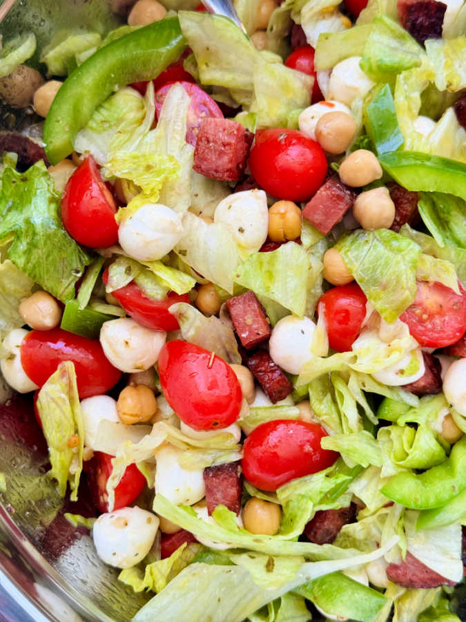 zoomed in picture of salad ingredients in the metal mixing bowl