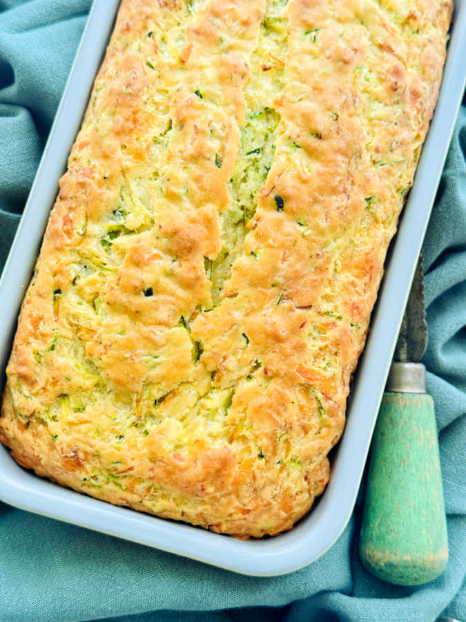 freshly baked loaf of savory zucchini bread in the pan ready to be sliced