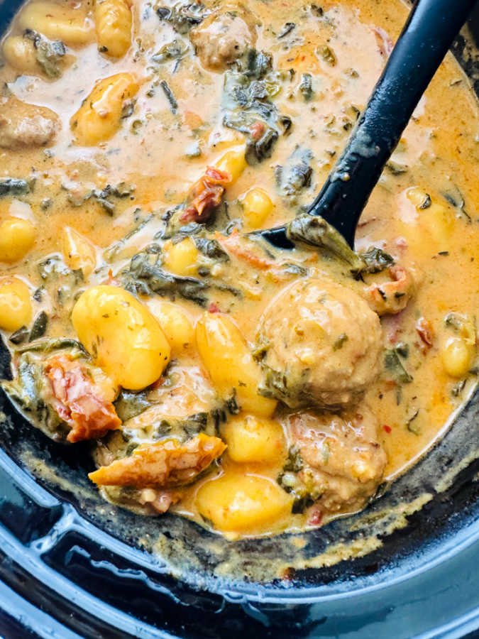 Spooning out a serving of marry me meatballs with gnocchi from the Crock-Pot