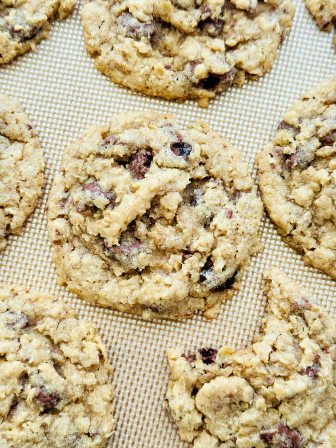 freshly baked oatmeal cookies on a silpat lined baking sheet
