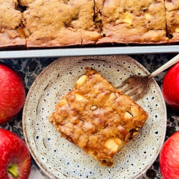 a plated sour cream apple square with some fresh red apples off to the side