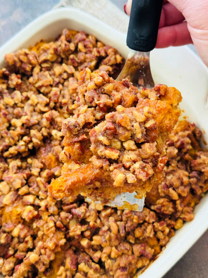 serving the first slice of pumpkin french toast from the baking dish