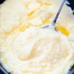 a crock full of creamy mashed potatoes ready to serve