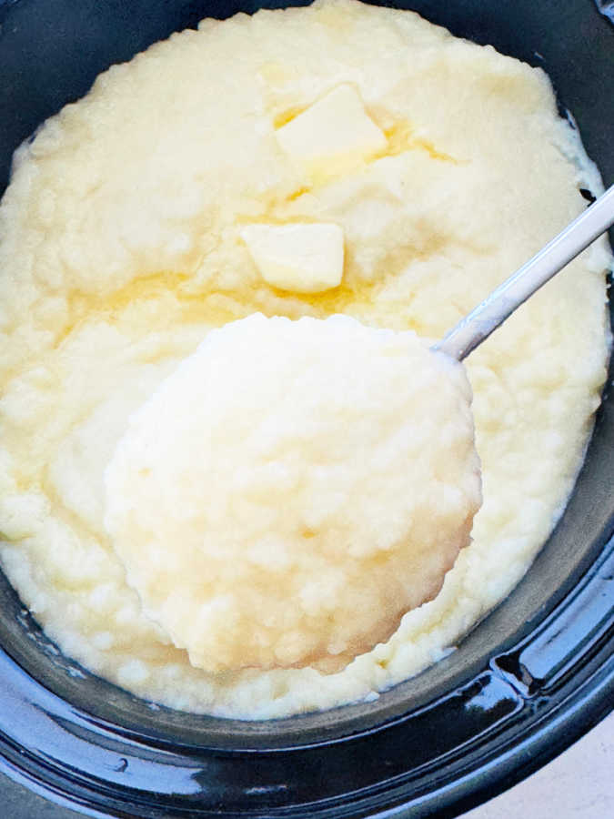 serving a spoonful of mashed potatoes directly from the crockpot