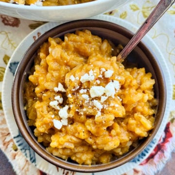 a bowl of pumpkin risotto garnished with feta cheese