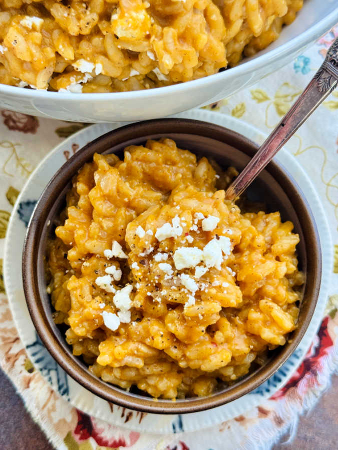 a bowl of pumpkin risotto garnished with feta cheese