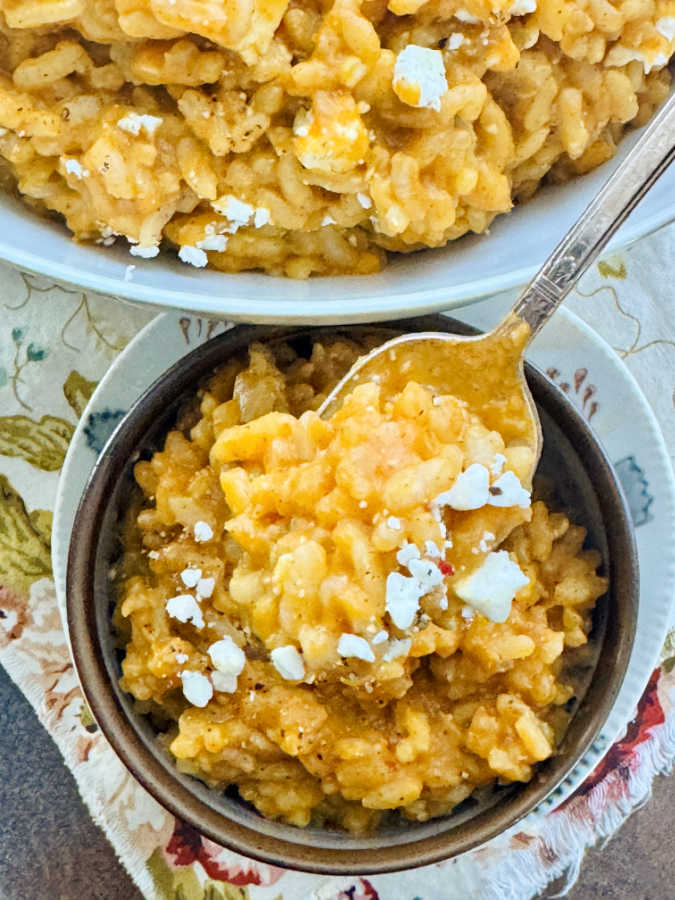 a close up photo of a spoonful of pumpkin risotto