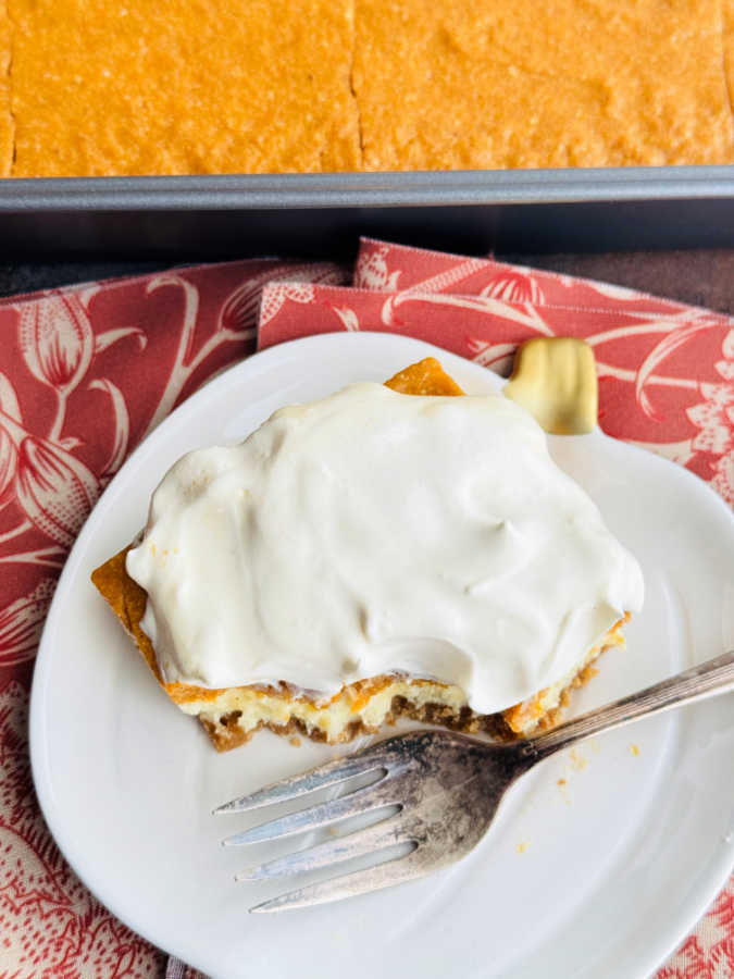 showing a half eaten slice of pumpkin torte on a pumpkin shaped dessert plate