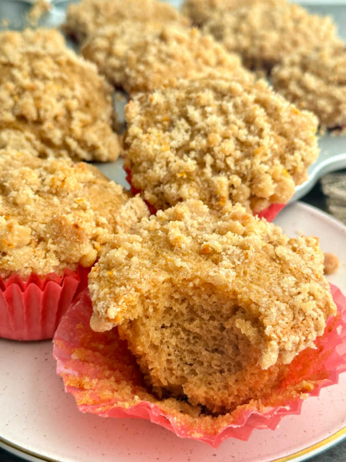 a plate of three muffins and one of them has a bite taken