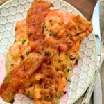 Kentucky hot brown sandwich on a plate with a knife and fork