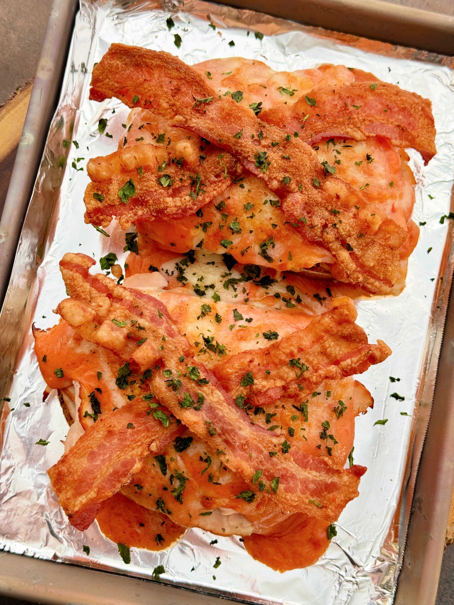two open-faced sandwiches on a baking sheet after being broiled