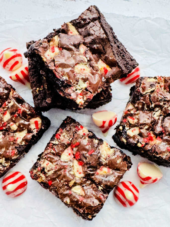 freshly baked peppermint brownies cut and displayed with unwrapped candy cane kisses