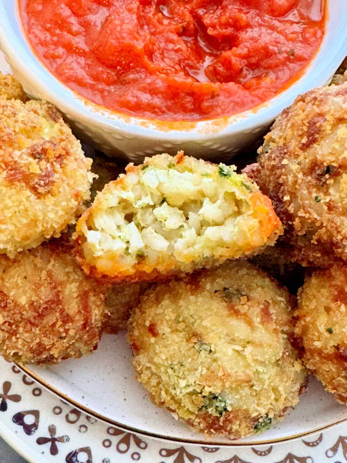 plated arancini rice balls with a small bowl of pizza sauce for dipping