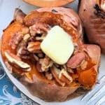 air fryer roasted sweet potato topped with brown sugar, pecans and a pat of butter