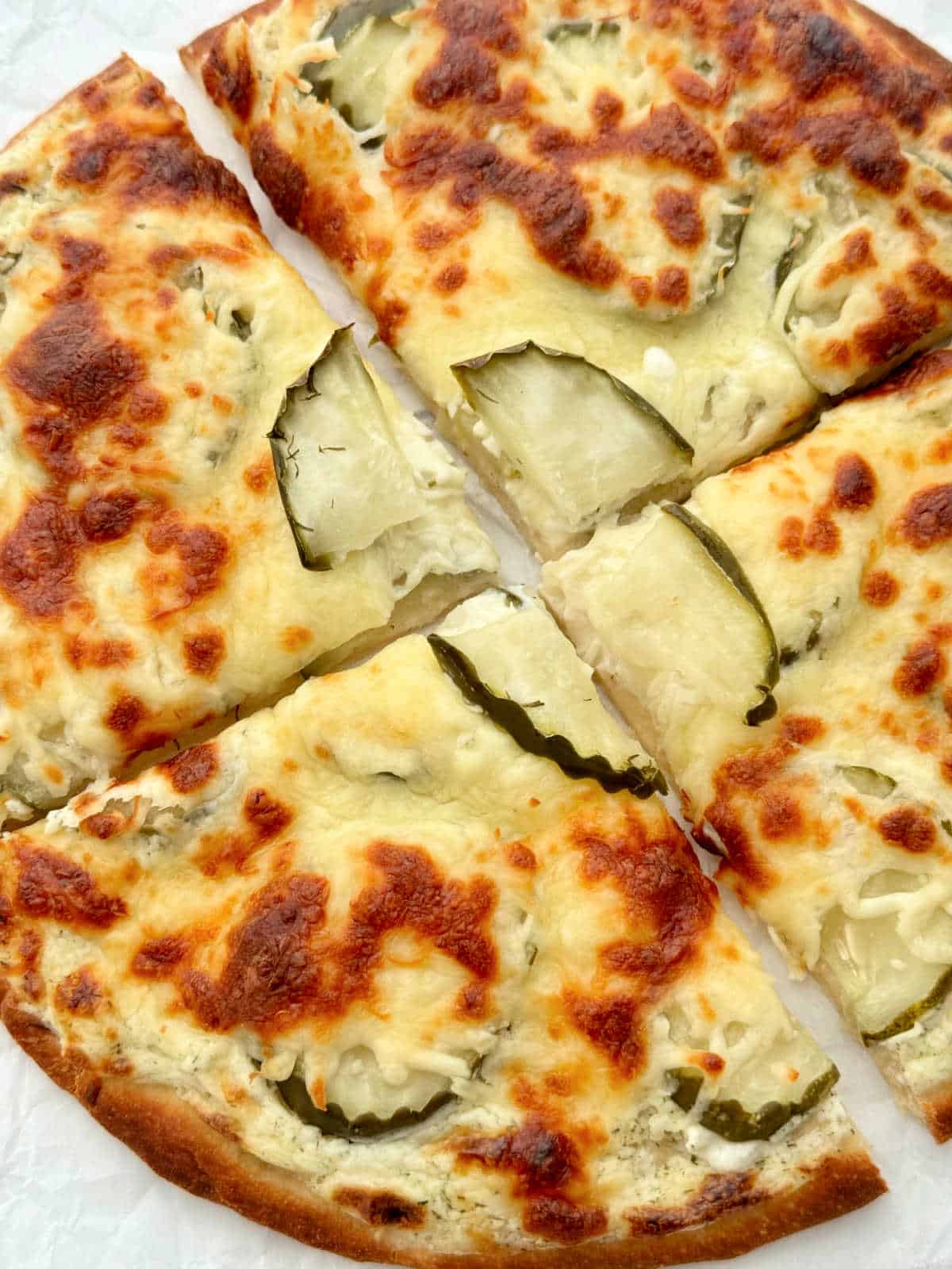 freshly baked pickle pizza sliced and ready to eat
