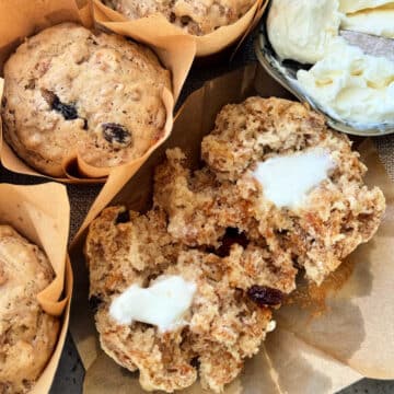 raisin bran muffins in a grouping with one cut in half and spread with butter