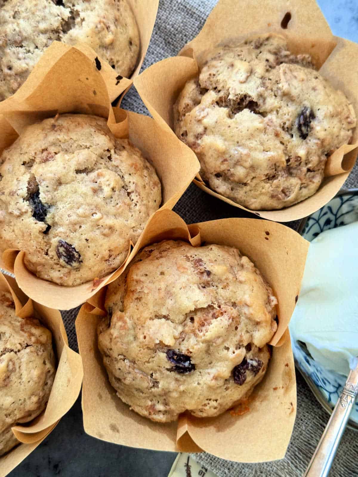 a grouping of freshly baked raisin bran muffins with butter for spreading