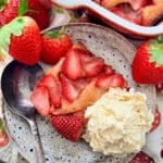 a plated slice of strawberry cobbler with a scoop of vanilla ice cream