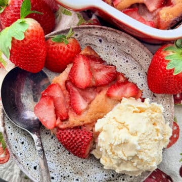 a plated slice of strawberry cobbler with a scoop of vanilla ice cream