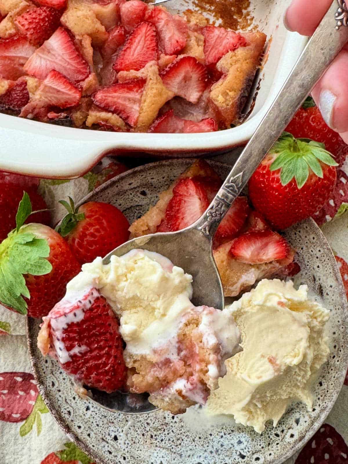 eating a spoonful of strawberry cobbler and ice cream