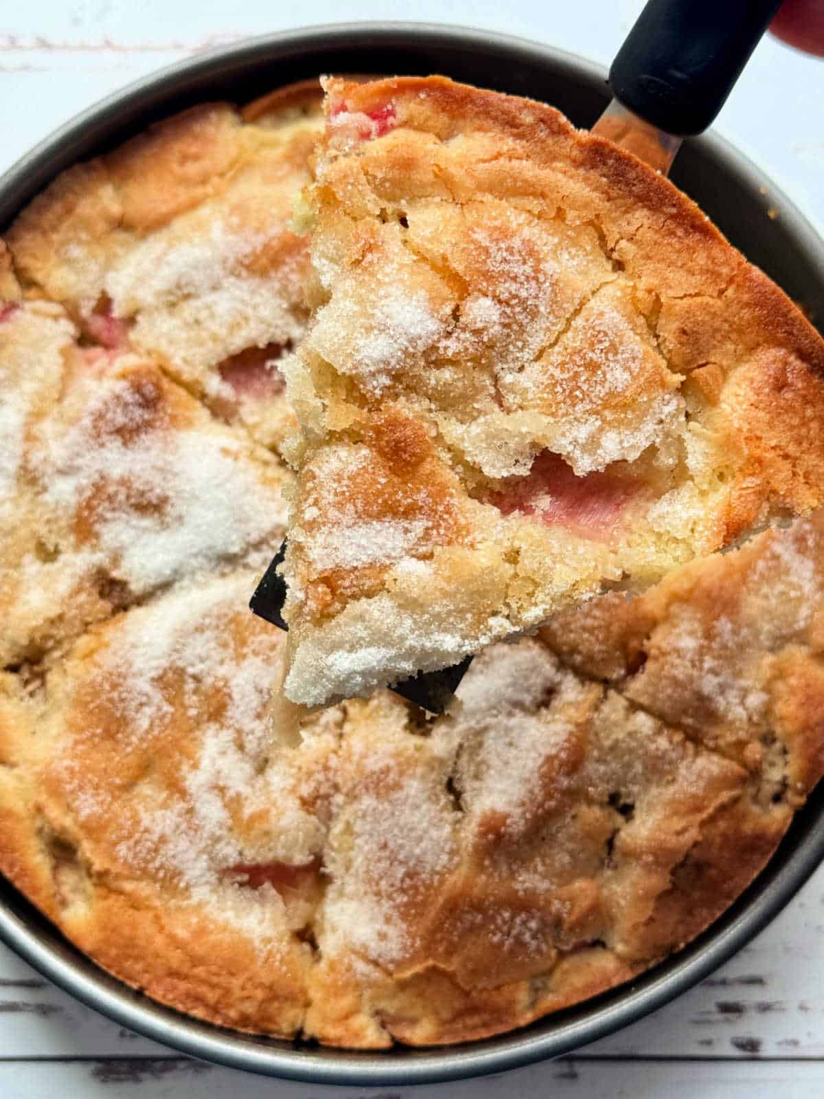 serving a slice of rhubarb cake from the pan