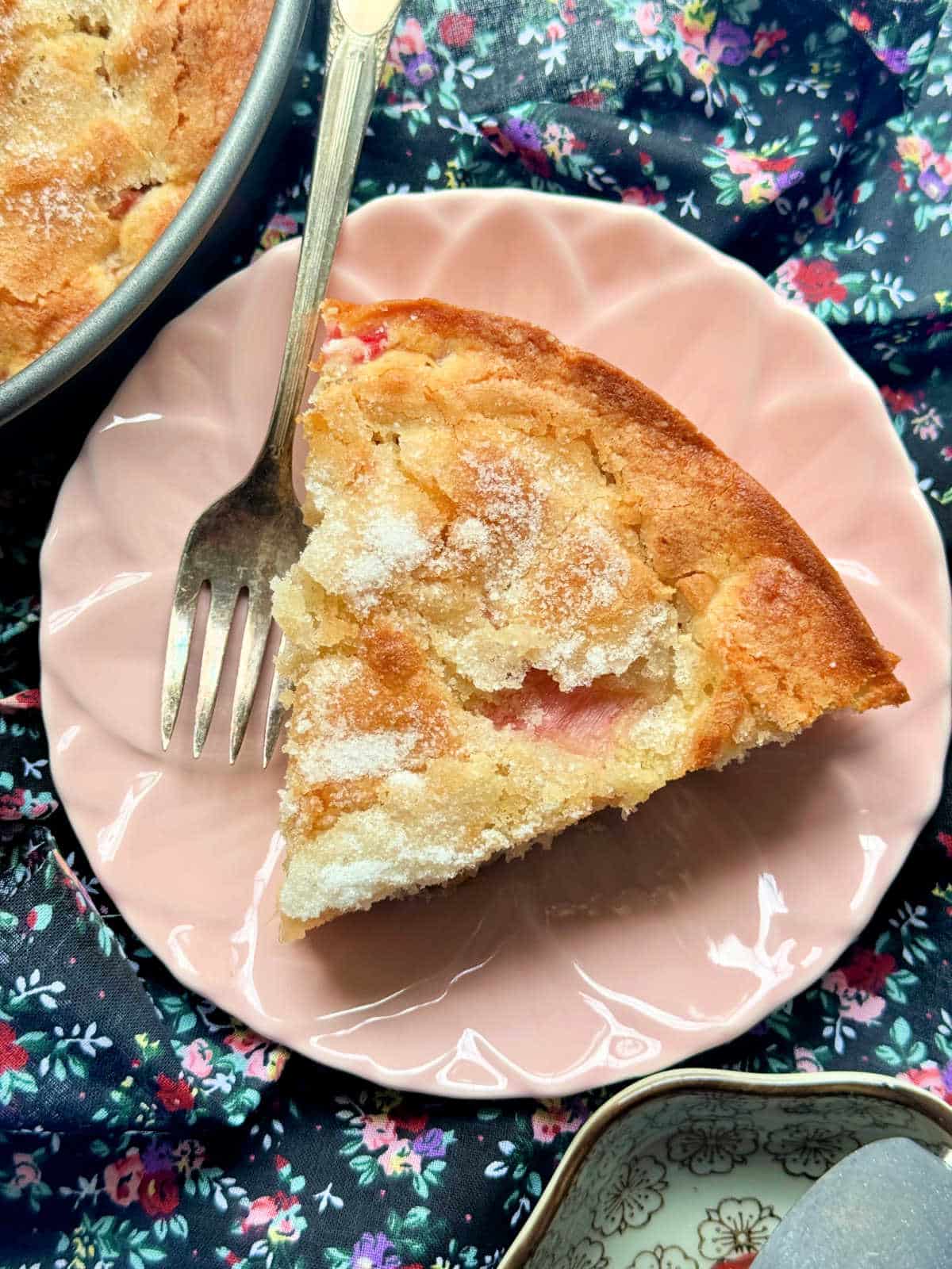 a slice of rhubarb cake on a pink plate