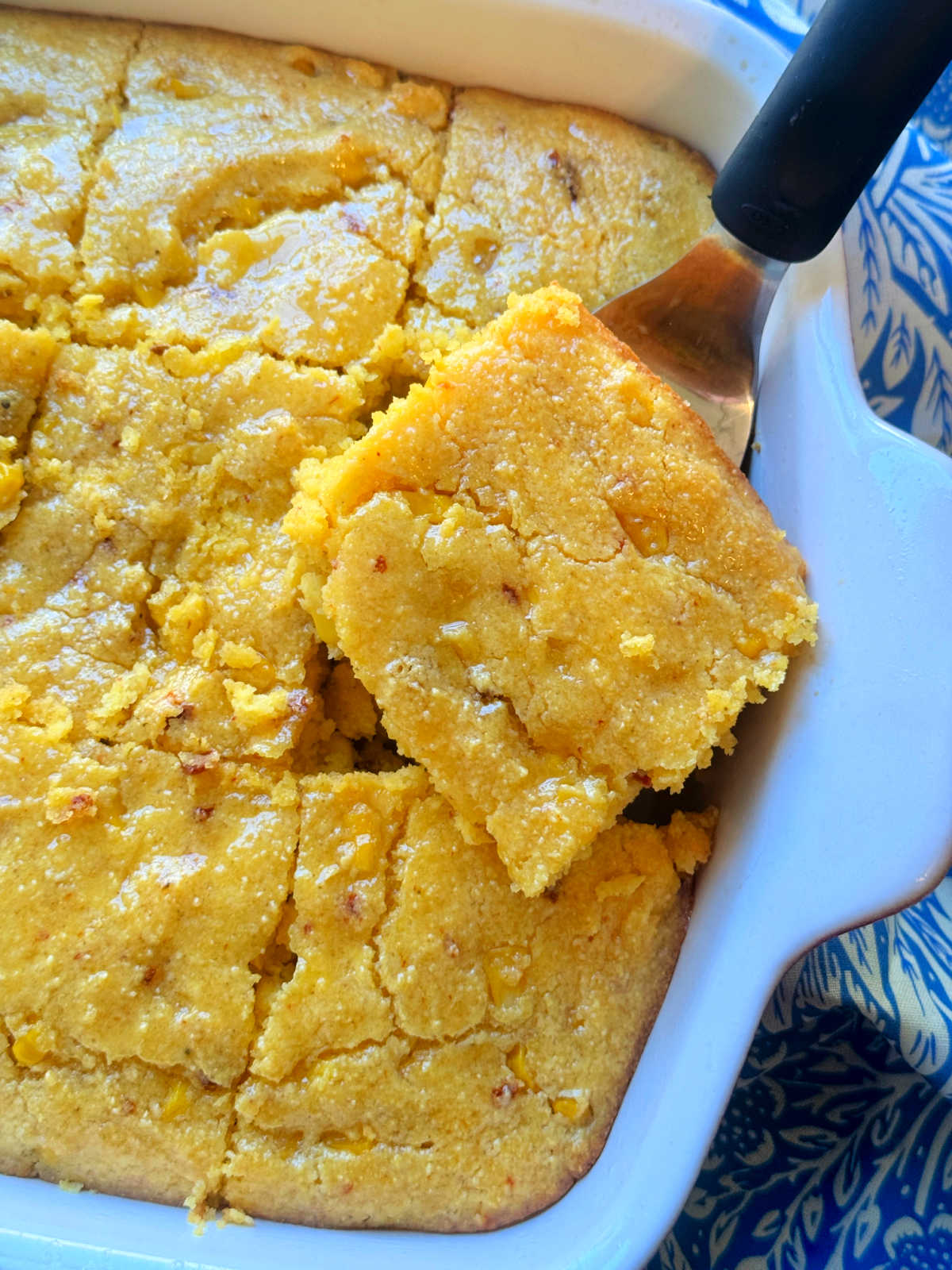serving a slice of cornbread casserole from the baking dish