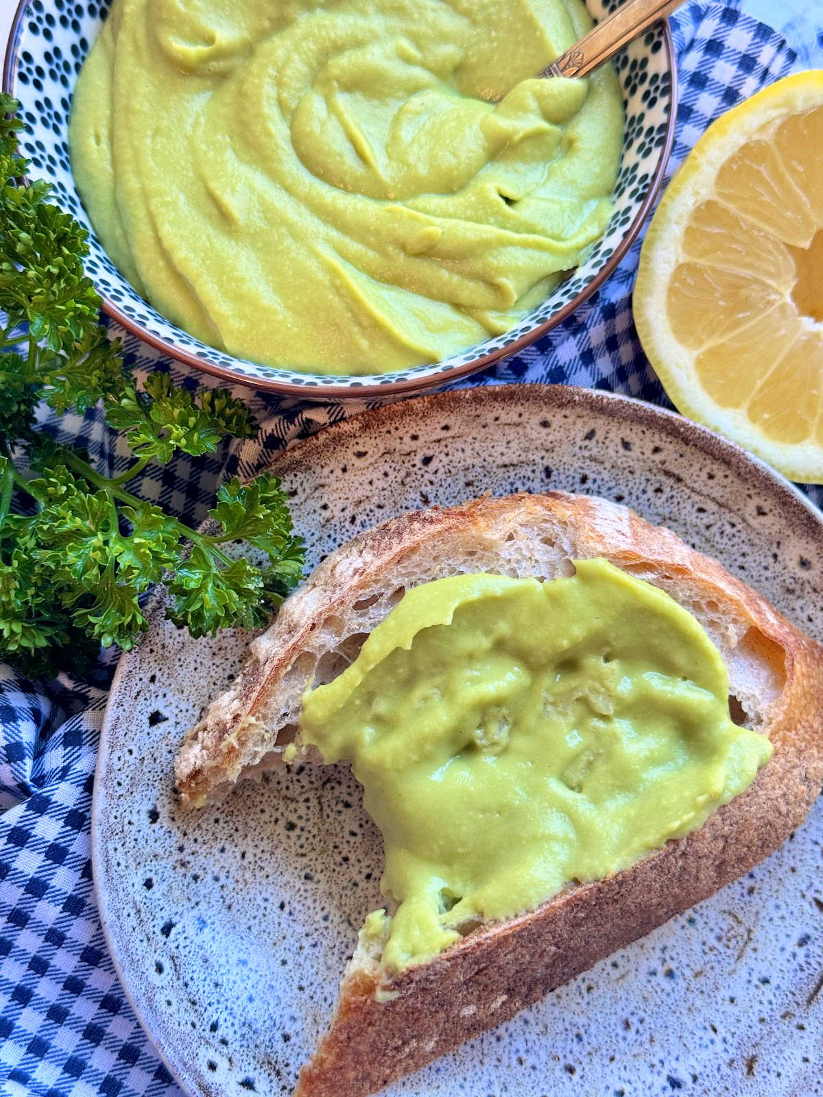 bean butter spread on a slice of artisan bread with a bite taken out of it