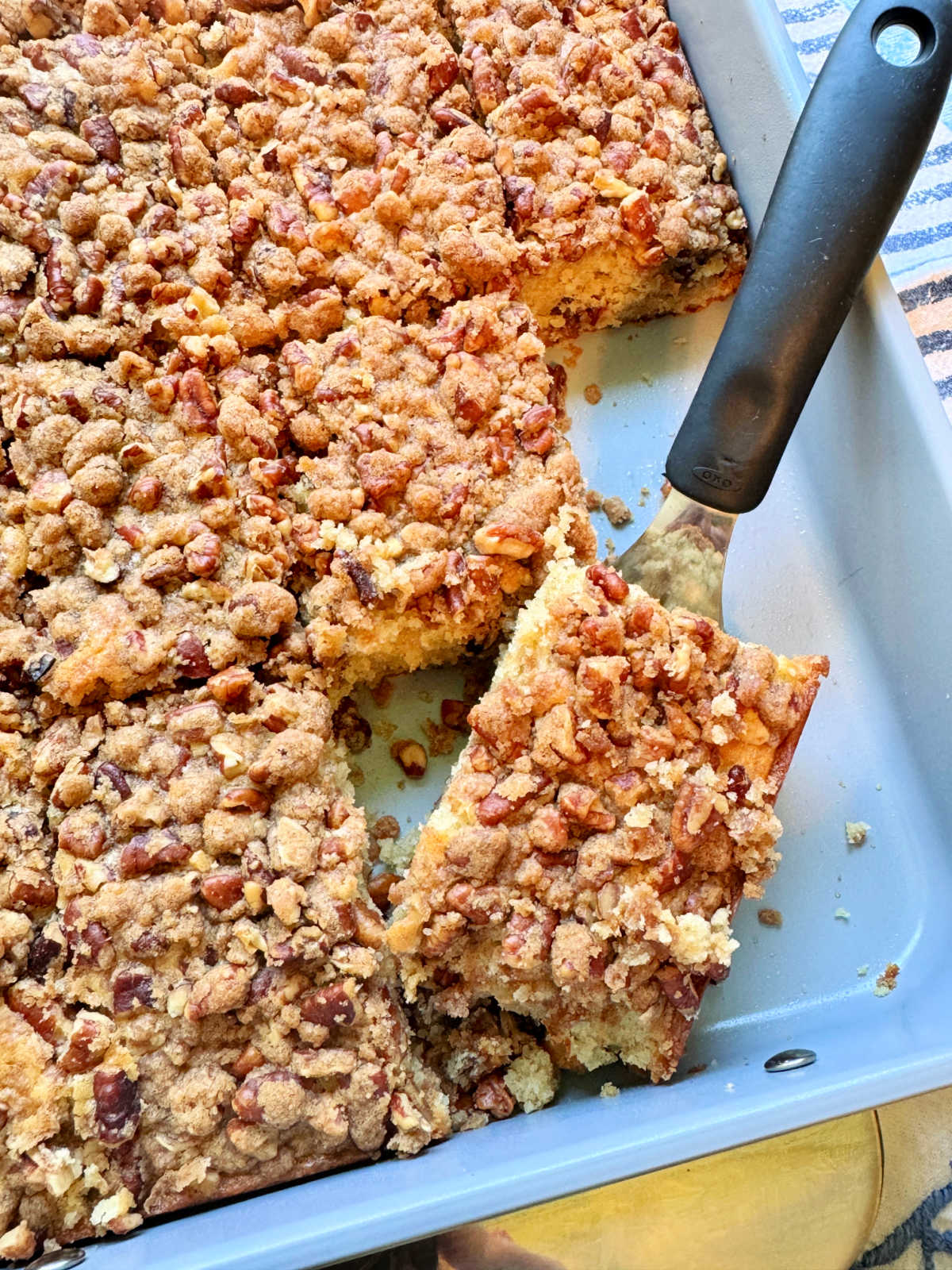 serving a slice of cinnamon coffee cake from the pan