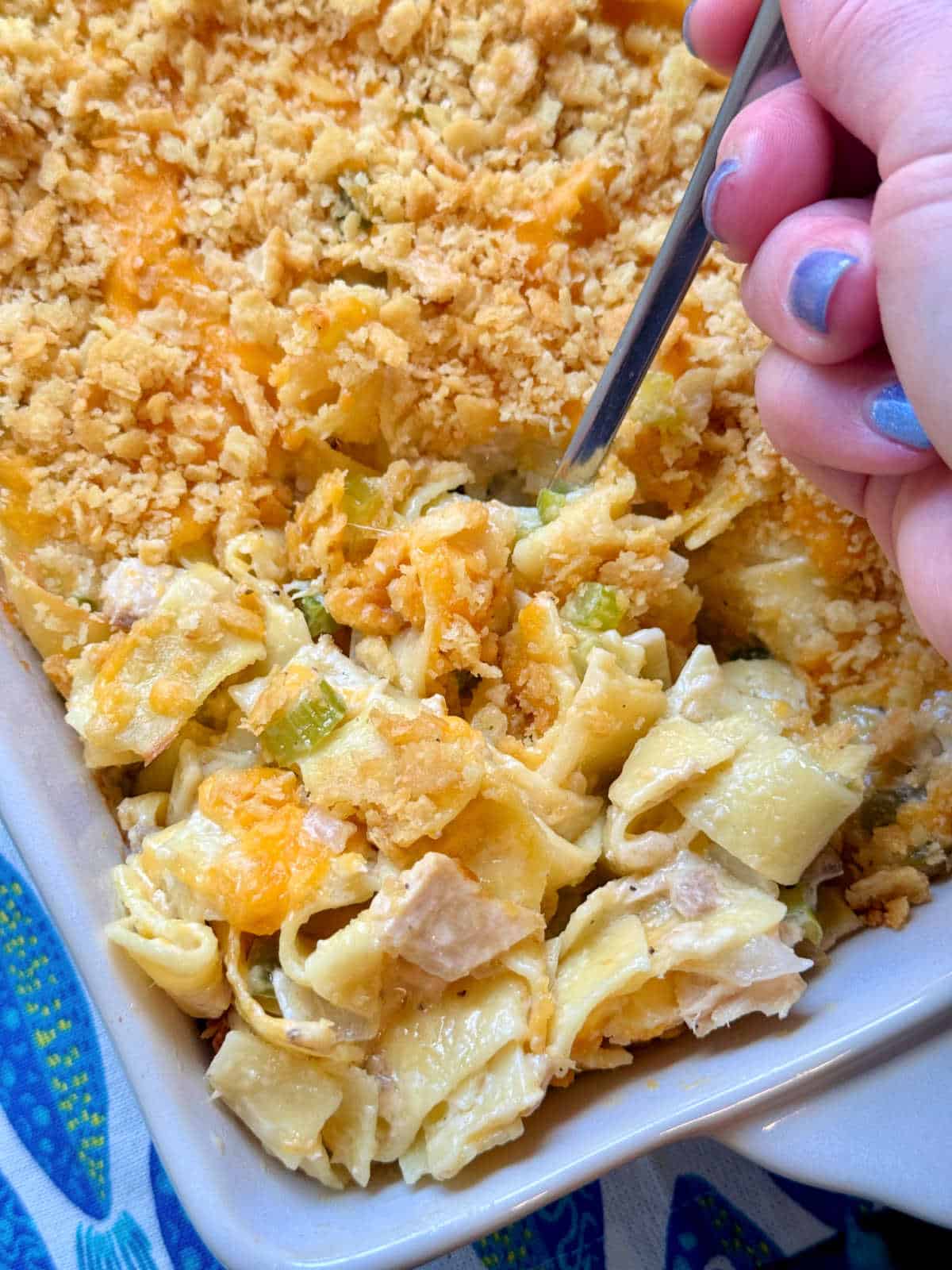 serving a spoonful of tuna casserole from the baking dish